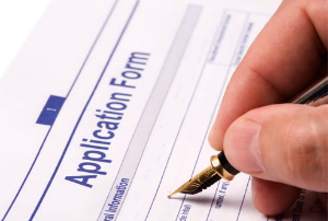 hand with a pen on an application form