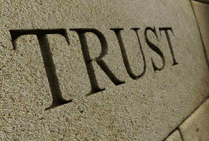 The word TRUST carved into a stone wall.