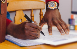hands with pen signing a contract
